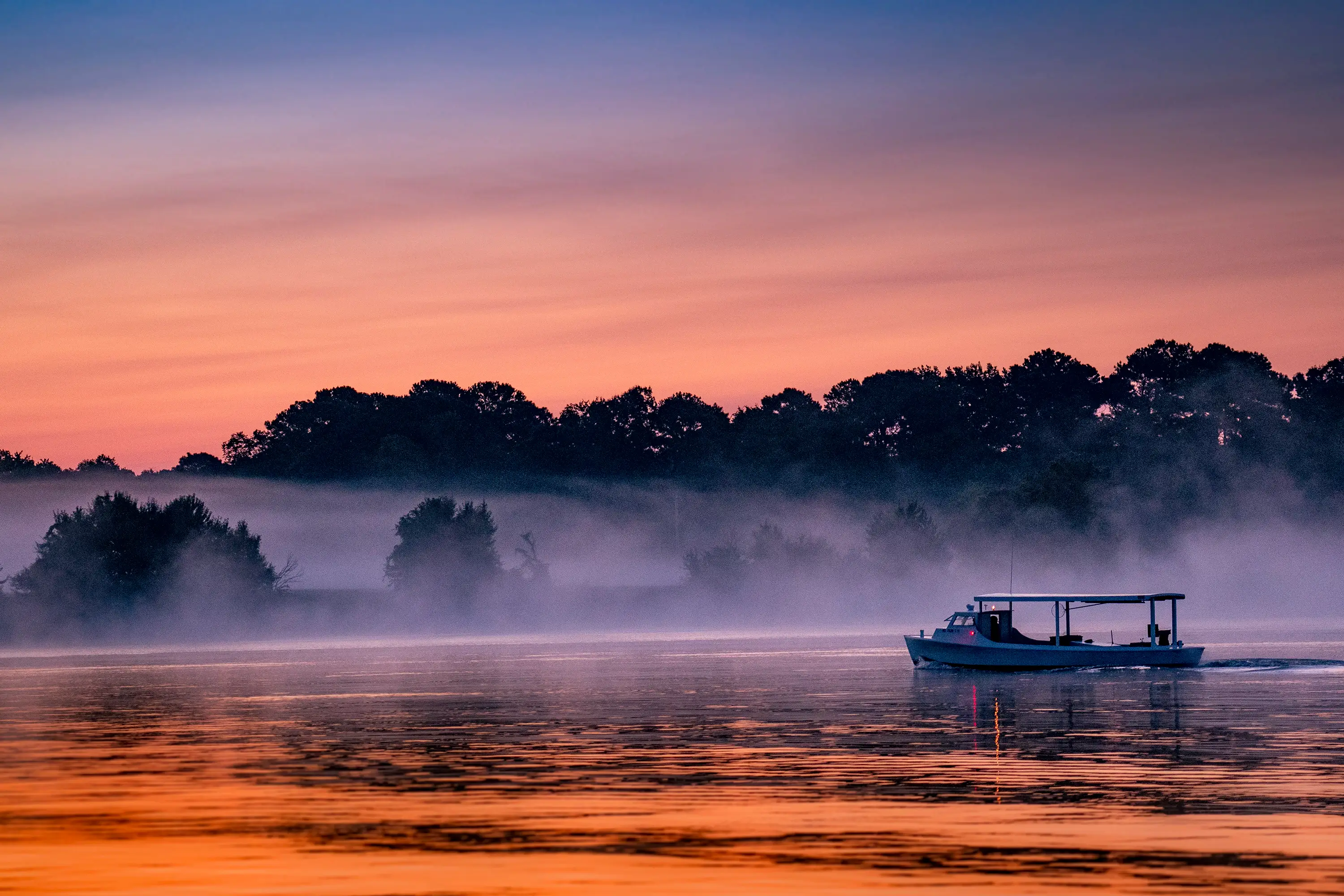 A boat on the water at sunset.