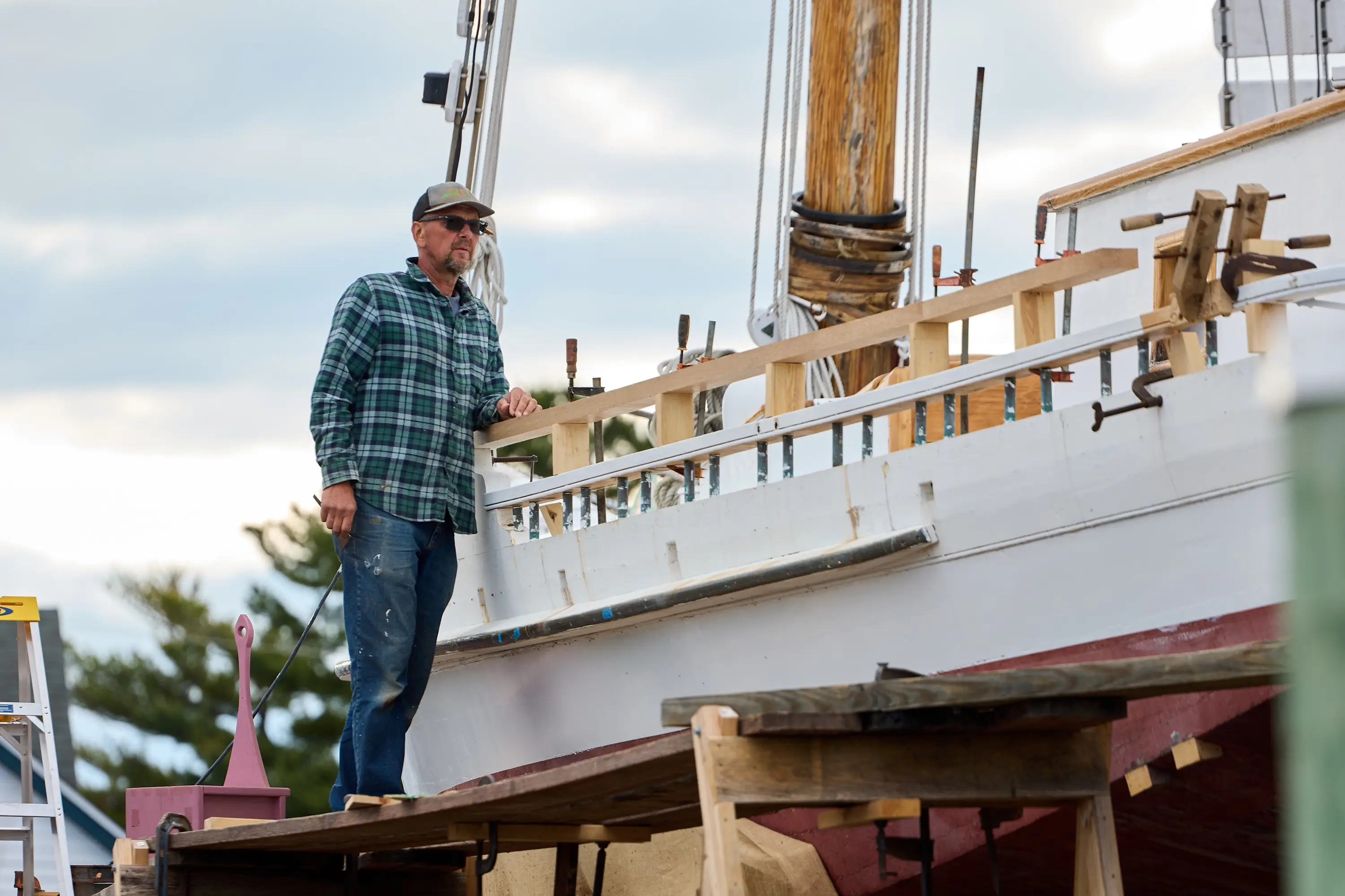 A man standing on a platform working on a boat